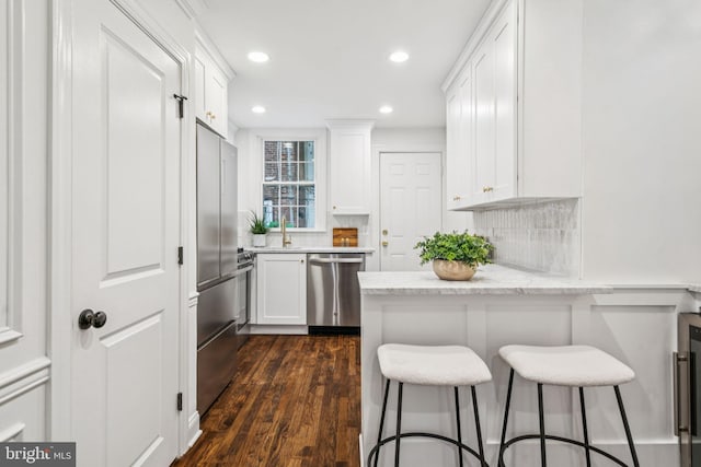 1935 S Hemberger St, Philadelphia, PA 19145 - kitchen featuring appliances with stainless steel finishes, white cabinets, a kitchen bar, and recessed lighting