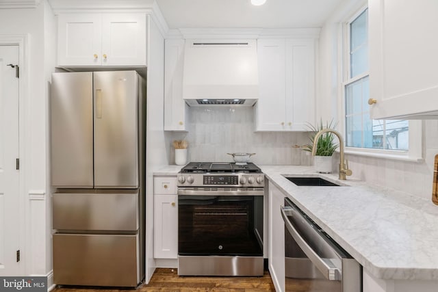 1935 S Hemberger St, Philadelphia, PA 19145 - kitchen with appliances with stainless steel finishes, custom exhaust hood, white cabinets, and decorative backsplash