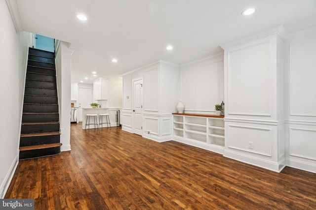 1935 S Hemberger St, Philadelphia, PA 19145 - unfurnished living room with dark wood-type flooring, stairs, ornamental molding, recessed lighting, and a decorative wall