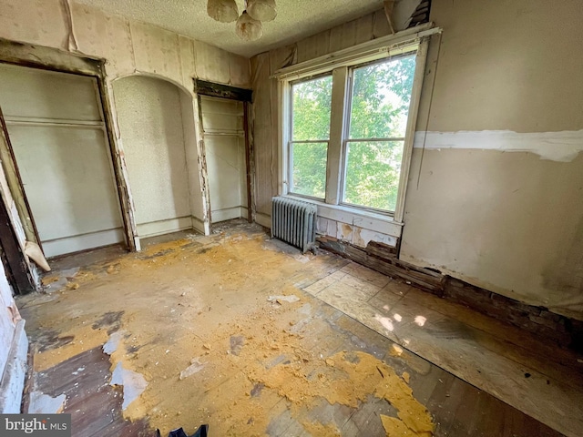 1510 Baird Blvd, Camden, NJ 08103 - unfurnished bedroom with radiator heating unit, a textured ceiling, and two closets
