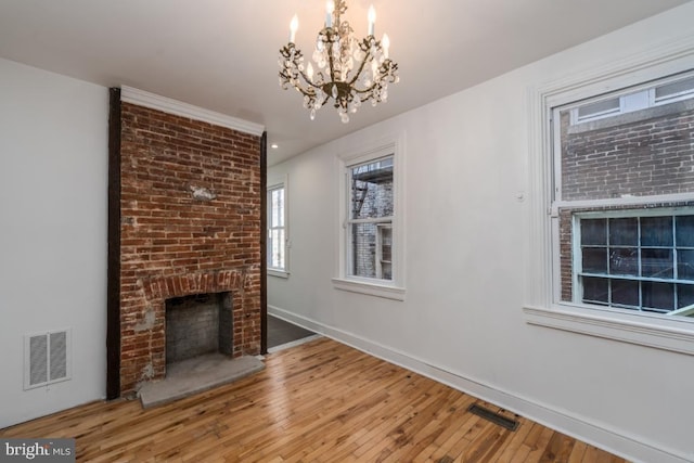 525 Scott St, Baltimore, MD 21230 - unfurnished living room featuring a fireplace, a chandelier, and wood finished floors