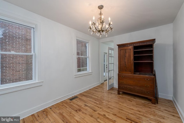 525 Scott St, Baltimore, MD 21230 - spare room with light wood-style floors and a chandelier