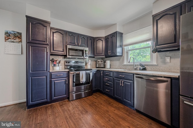 2811 Green St, Claymont, DE 19703 - kitchen with stainless steel appliances, dark wood-type flooring, backsplash, and light stone countertops