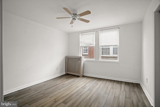 7019 Algard St, Philadelphia, PA 19135 - unfurnished room with wood finished floors, a ceiling fan, and radiator