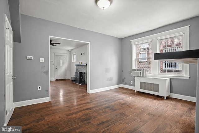 7019 Algard St, Philadelphia, PA 19135 - unfurnished living room with radiator heating unit, wood finished floors, a fireplace, and ceiling fan