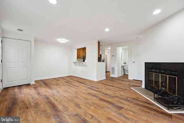 24 Whitechurch Ct, Germantown, MD 20874 - unfurnished living room featuring wood finished floors, recessed lighting, and a glass covered fireplace
