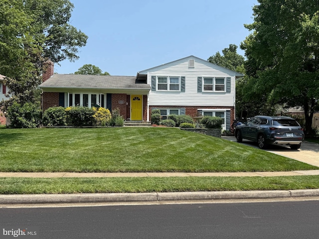 8323 Blowing Rock Rd, Alexandria, VA 22309 - tri-level home with a front lawn, brick siding, a chimney, and driveway