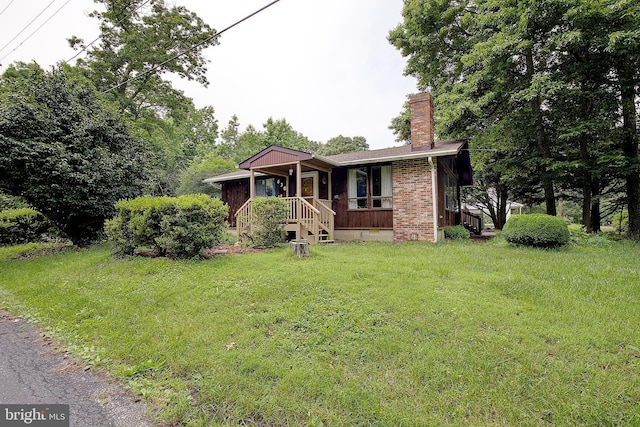 638 Los Alamos Ln, Lusby, MD 20657 - view of front of property featuring a chimney, a front lawn, and brick siding