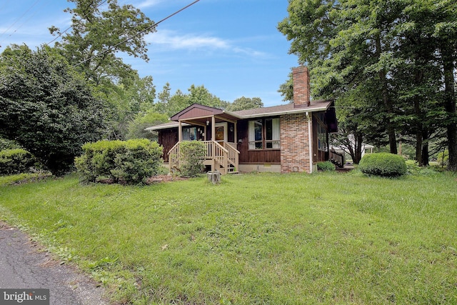 638 Los Alamos Ln, Lusby, MD 20657 - view of front facade with a chimney, a front yard, and brick siding