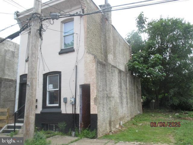 1142 W Nevada St, Philadelphia, PA 19133 - view of property exterior with stucco siding and a chimney