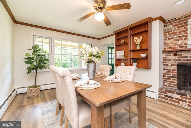 559 Maple Ave, Doylestown, PA 18901 - dining room featuring light wood finished floors, ornamental molding, a ceiling fan, a fireplace, and a baseboard radiator