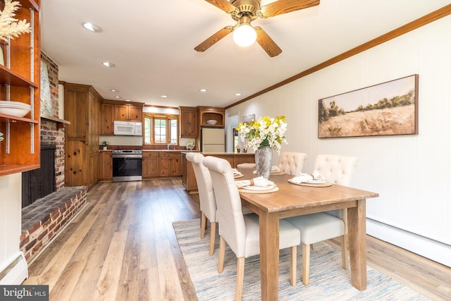 559 Maple Ave, Doylestown, PA 18901 - dining room with crown molding, light wood finished floors, a ceiling fan, a baseboard heating unit, and a fireplace