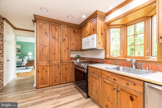 559 Maple Ave, Doylestown, PA 18901 - kitchen with stainless steel appliances, ornamental molding, brown cabinets, light wood finished floors, and recessed lighting