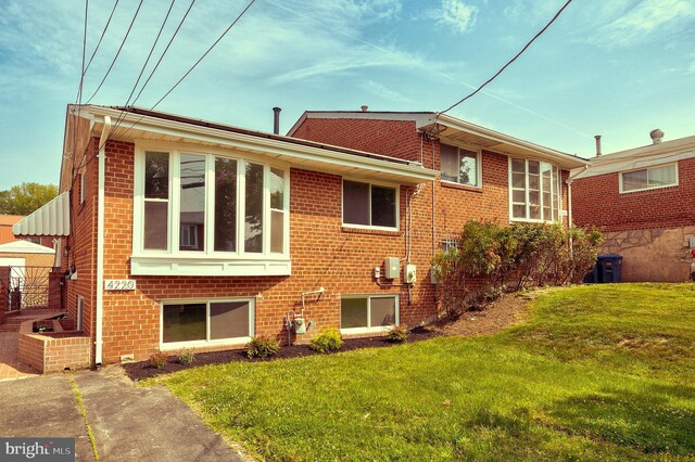 4220 Fort Dupont St SE, Washington, DC 20020 - rear view of property featuring a yard and brick siding