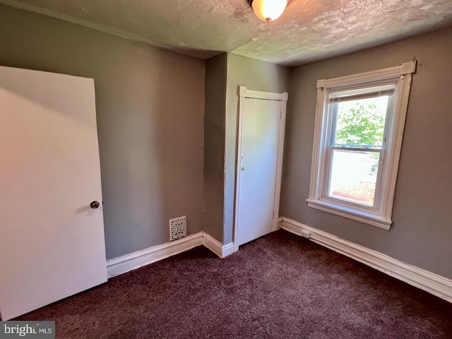 305 Delamore Pl, Wilmington, DE 19805 - unfurnished bedroom with dark colored carpet, a closet, and a textured ceiling