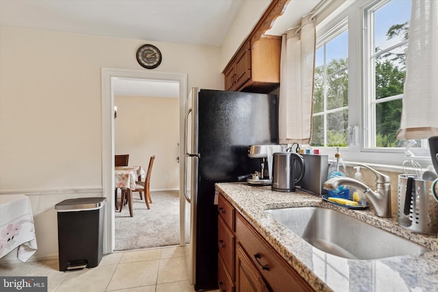 709 Parmentier Rd, Warminster, PA 18974 - kitchen with brown cabinets, plenty of natural light, light stone countertops, and freestanding refrigerator