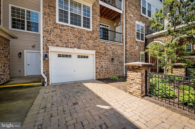 625 Quarry View Ct Unit 208, Reisterstown, MD 21136 - view of exterior entry featuring an attached garage, decorative driveway, and brick siding