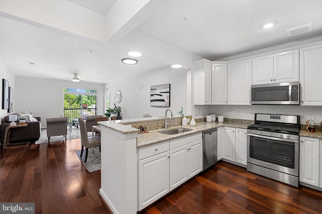 625 Quarry View Ct Unit 208, Reisterstown, MD 21136 - kitchen featuring stainless steel appliances, a peninsula, white cabinetry, dark wood-type flooring, and light stone countertops