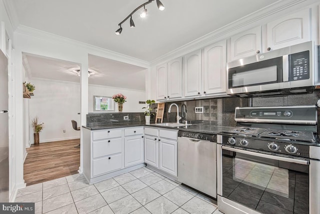 349 Homeland Southway Unit 1A, Baltimore, MD 21212 - kitchen featuring appliances with stainless steel finishes, white cabinetry, backsplash, ornamental molding, and light tile patterned floors
