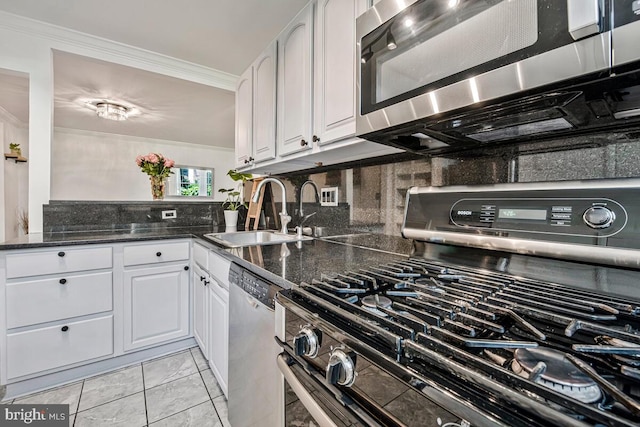 349 Homeland Southway Unit 1A, Baltimore, MD 21212 - kitchen with appliances with stainless steel finishes, decorative backsplash, ornamental molding, white cabinetry, and dark stone counters