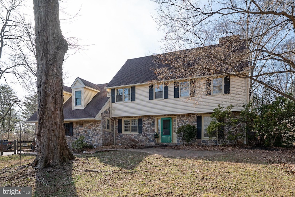718 S Waterloo Rd, Devon, PA 19333 - view of front of property featuring stone siding, a chimney, a shingled roof, and a front lawn