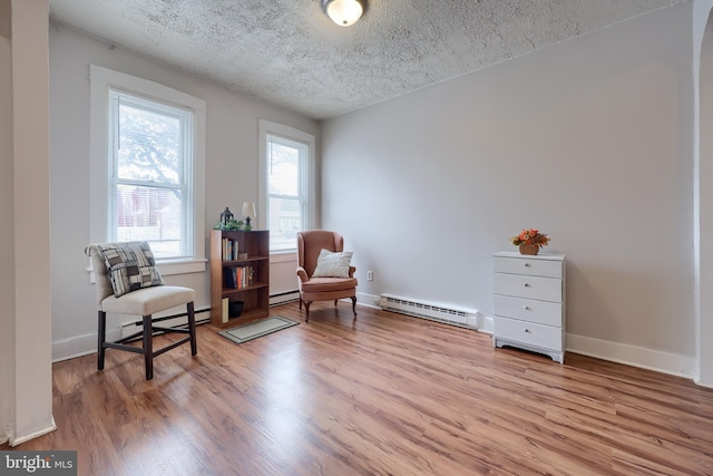 68 Locust St, Lancaster, PA 17602 - sitting room with a baseboard radiator, baseboard heating, light wood finished floors, and a textured ceiling