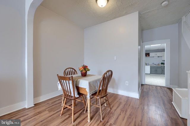 68 Locust St, Lancaster, PA 17602 - dining area with wood finished floors, arched walkways, and a textured ceiling