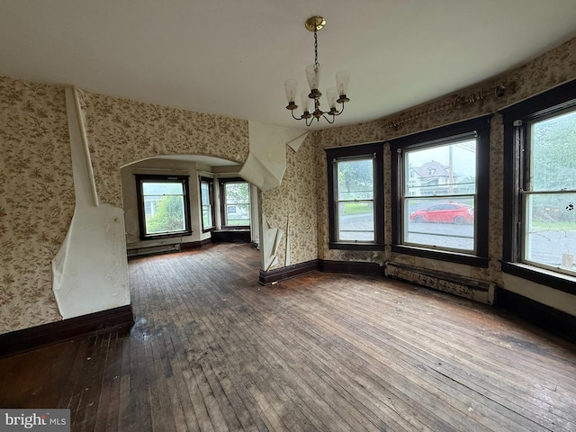 77 Spring St, Beaver Springs, PA 17812 - unfurnished dining area featuring wallpapered walls, wood-type flooring, a chandelier, arched walkways, and plenty of natural light