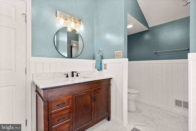 10207 Daylily Ct, Manassas, VA 20110 - bathroom with wainscoting, vanity, lofted ceiling, and tile patterned flooring
