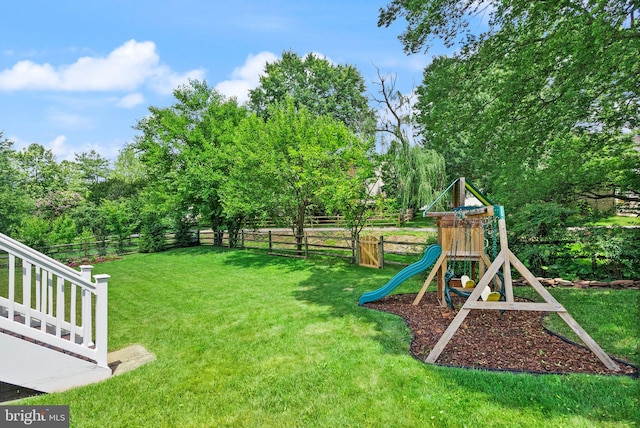 10207 Daylily Ct, Manassas, VA 20110 - fenced backyard featuring a playground and view of wooded area
