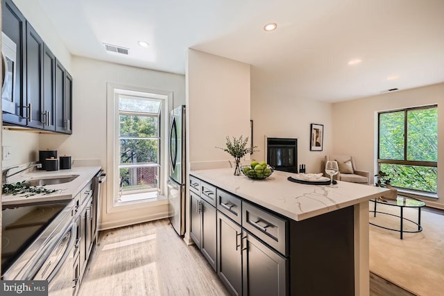 108 W Barre St Unit R 48, Baltimore, MD 21201 - kitchen with freestanding refrigerator, light stone countertops, light wood-style flooring, open floor plan, and recessed lighting
