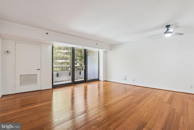 1200 Crystal Dr Unit 514, Arlington, VA 22202 - unfurnished room featuring wood finished floors, a wall of windows, and a ceiling fan