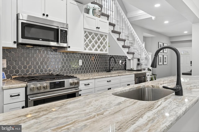 30 Race Ave, Lancaster, PA 17603 - kitchen with appliances with stainless steel finishes, white cabinetry, light stone countertops, backsplash, and recessed lighting