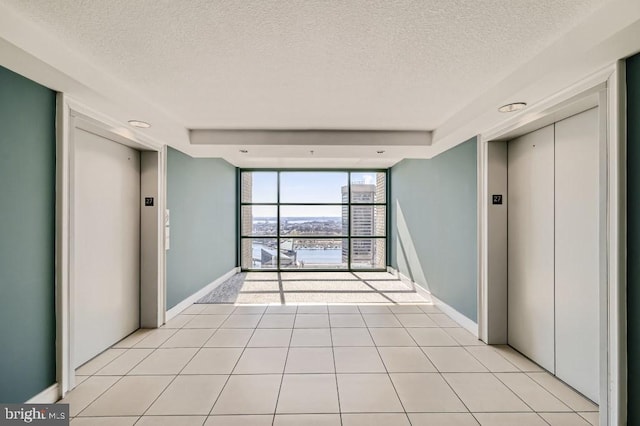 414 Water St Unit 2814, Baltimore, MD 21202 - spare room featuring elevator, a textured ceiling, floor to ceiling windows, and light tile patterned floors