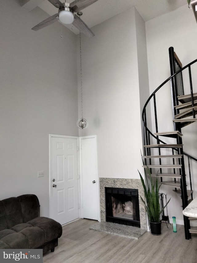 14007 Vista Dr Unit 30, Laurel, MD 20707 - living room featuring wood finished floors, stairs, a high ceiling, ceiling fan, and a fireplace
