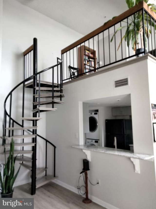 14007 Vista Dr Unit 30, Laurel, MD 20707 - stairway with stacked washer and clothes dryer, wood finished floors, and a high ceiling