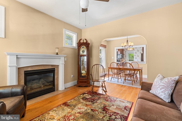 671 Edge Hill Rd, Glenside, PA 19038 - living area featuring arched walkways, a ceiling fan, wood finished floors, a fireplace with flush hearth, and a chandelier