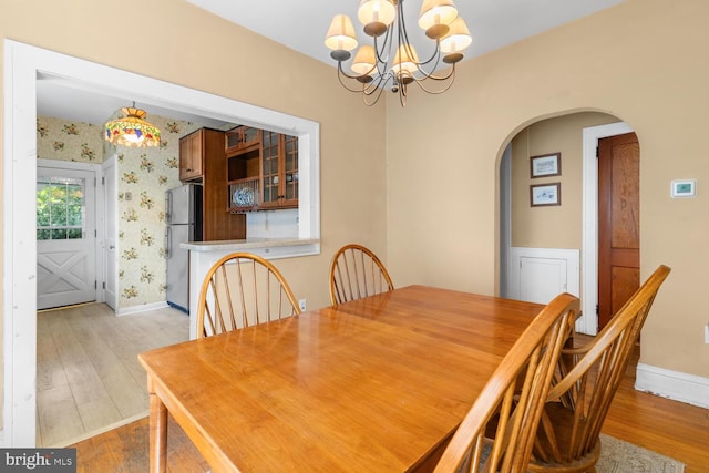 671 Edge Hill Rd, Glenside, PA 19038 - dining room with a chandelier, light wood-style flooring, arched walkways, and wallpapered walls