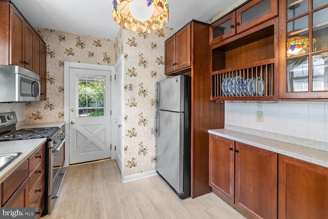 671 Edge Hill Rd, Glenside, PA 19038 - kitchen with stainless steel appliances, wallpapered walls, light wood-style flooring, light countertops, and glass insert cabinets