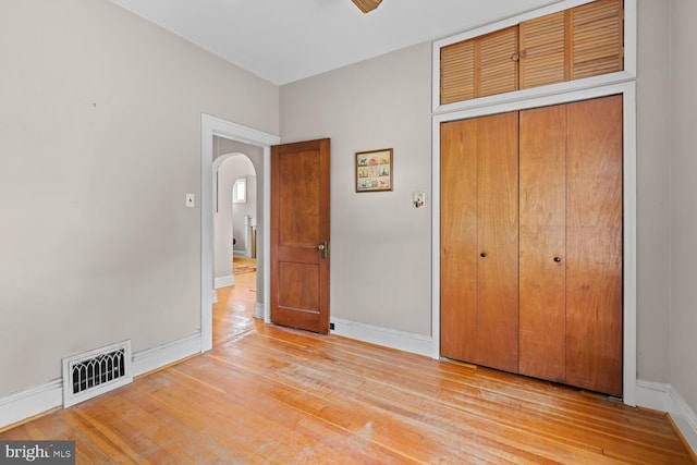671 Edge Hill Rd, Glenside, PA 19038 - unfurnished bedroom with arched walkways, a closet, and wood finished floors