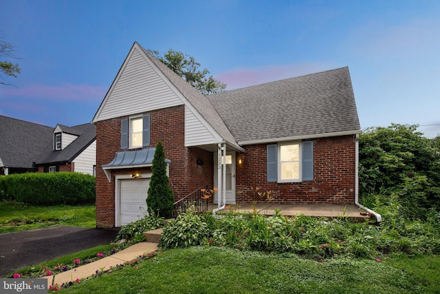 1233 E Ave, Abington, PA 19001 - view of front facade with brick siding, an attached garage, asphalt driveway, roof with shingles, and a front yard