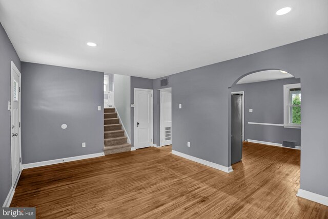 1233 E Ave, Abington, PA 19001 - unfurnished living room featuring arched walkways, wood finished floors, stairway, and recessed lighting