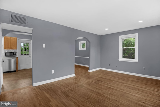 1233 E Ave, Abington, PA 19001 - empty room featuring arched walkways, plenty of natural light, dark wood finished floors, and recessed lighting