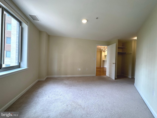 901 N Monroe St Unit 308, Arlington, VA 22201 - unfurnished bedroom featuring carpet flooring, multiple windows, a chandelier, and a closet