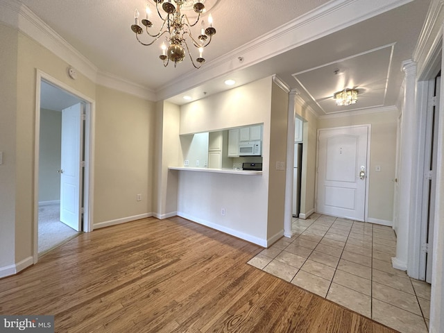 901 N Monroe St Unit 308, Arlington, VA 22201 - kitchen with white appliances, a chandelier, light wood-style floors, ornamental molding, and light countertops