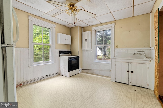527 Berwyn Baptist Rd, Berwyn, PA 19312 - kitchen with white electric range oven, wainscoting, healthy amount of natural light, ceiling fan, and light flooring