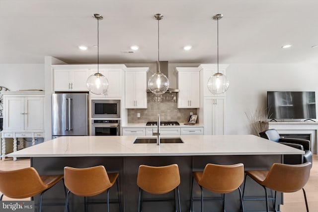 324 Star Tavern Ln, West Chester, PA 19382 - kitchen with stainless steel appliances, wall chimney range hood, white cabinets, decorative backsplash, and a center island with sink