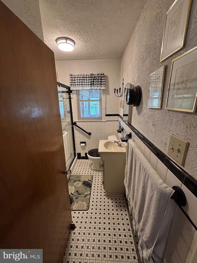 21 N Davis Ave, Audubon, NJ 08106 - bathroom featuring a textured ceiling, a stall shower, wainscoting, a textured wall, and tile patterned floors