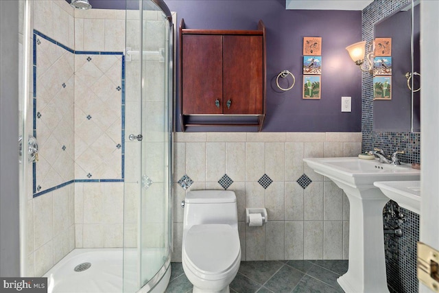 9210 Cherrytree Dr, Alexandria, VA 22309 - bathroom with a shower stall, tile walls, tile patterned flooring, and wainscoting