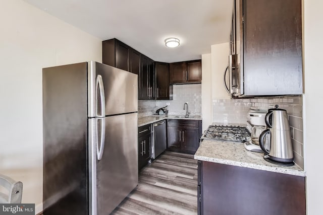 5851 Quantrell Ave Unit 407, Alexandria, VA 22312 - kitchen featuring stainless steel appliances, wood finished floors, light stone countertops, and decorative backsplash